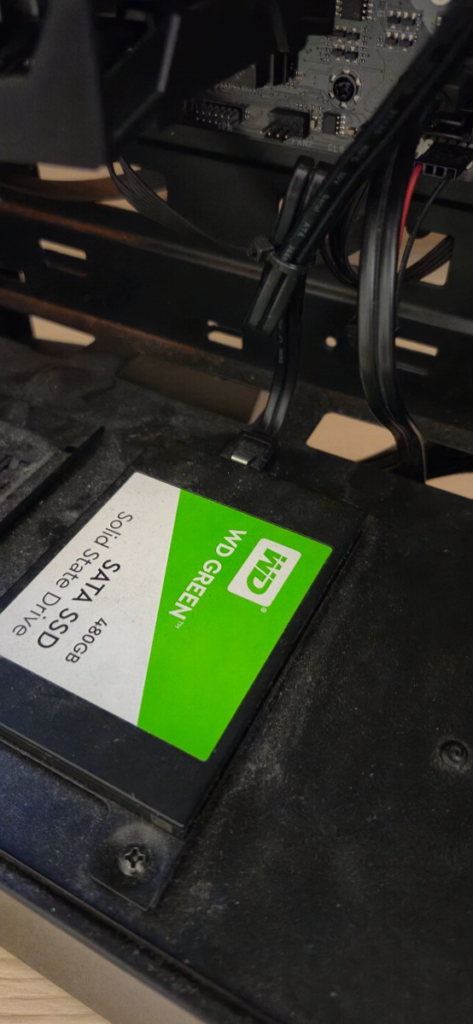 컴퓨터 본체에 고정된 WD Green 480GB 2.5인치 SSD 뒷면에 새 파워서플라이의 기억자(L) 모양 SATA 전원 케이블이 정확하게 꽂힌 근접 사진